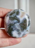 8th vein ocean jasper palm stone with white background and grey/brown orbing 